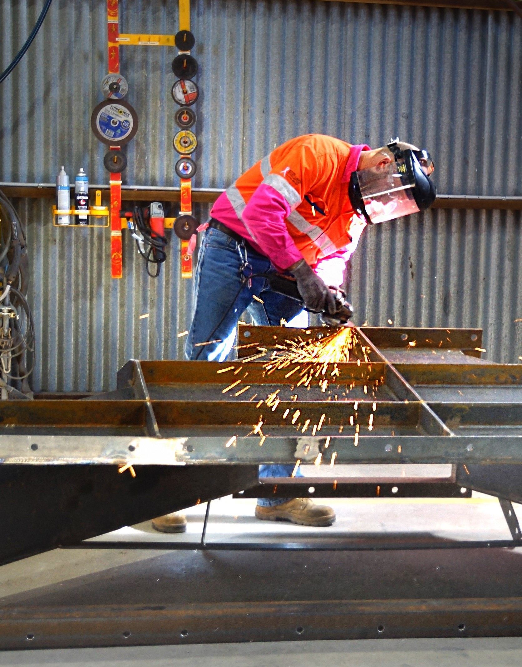 A man is cutting a piece of metal with a grinder