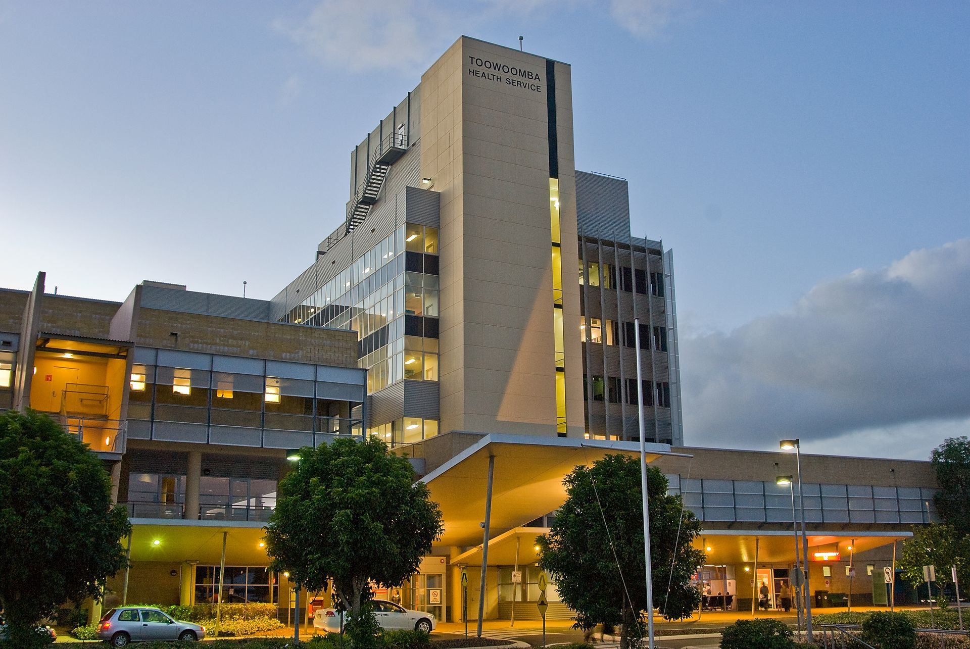 A large hospital with a lot of windows is lit up at night