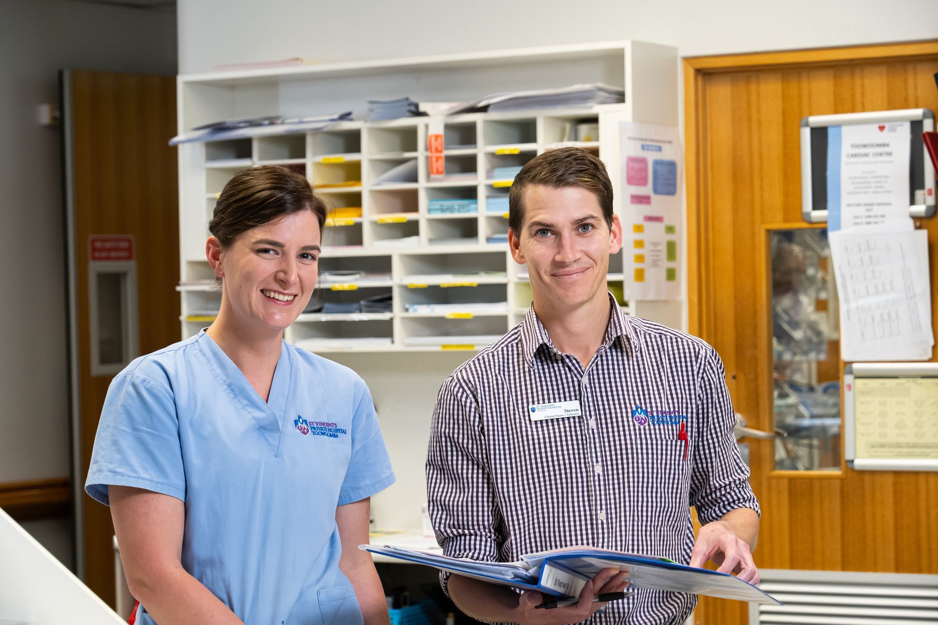 A man and a woman are standing next to each other in a hospital room.