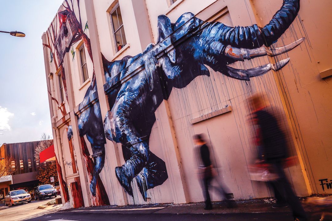An elephant is painted on the side of a building.