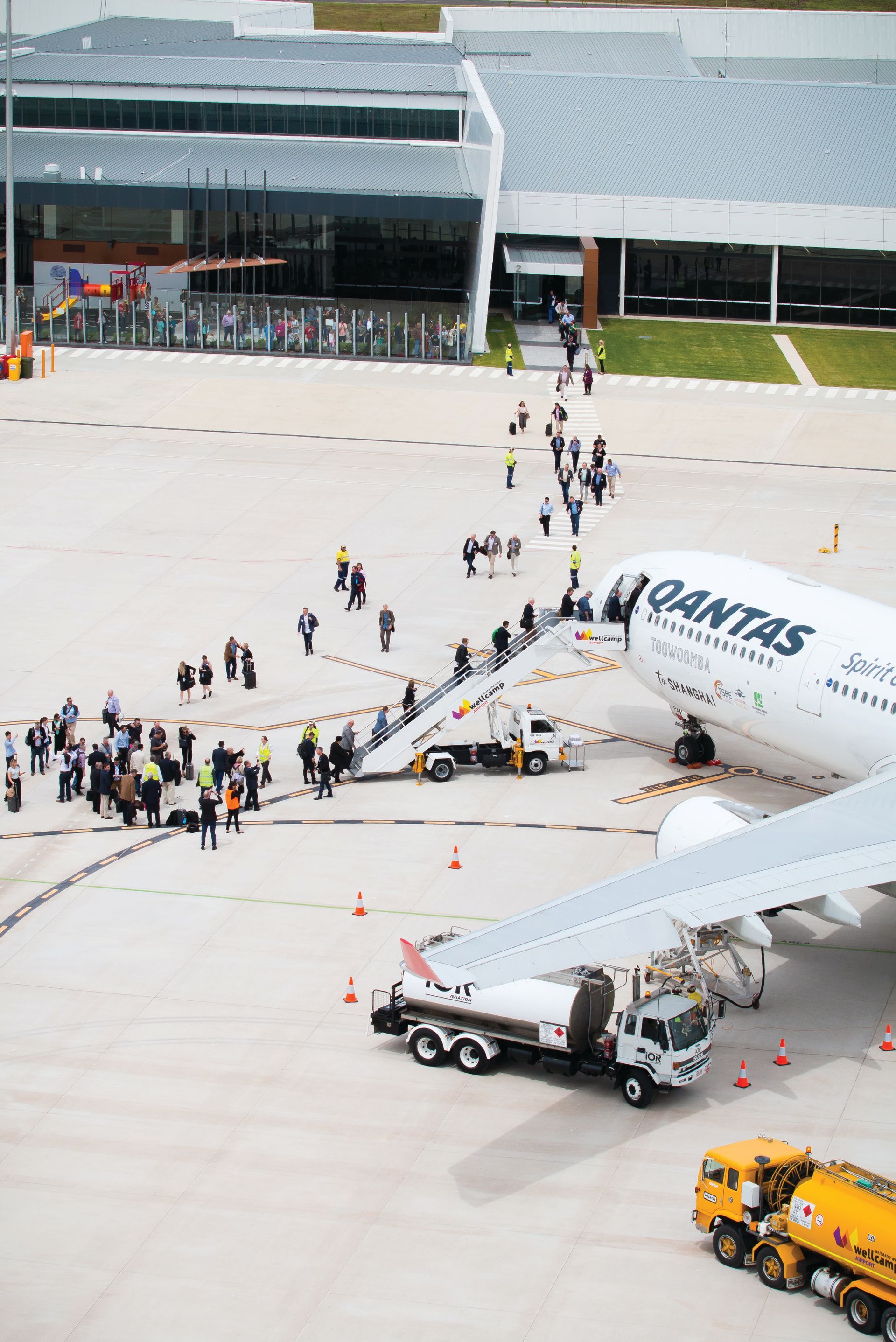 A group of people are boarding an airplane at an airport.