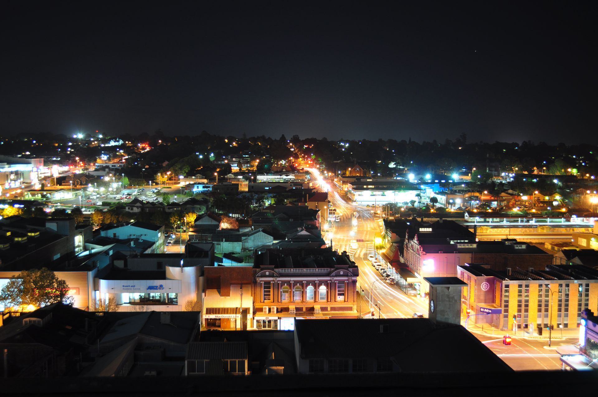 An aerial view of a city at night with buildings lit up