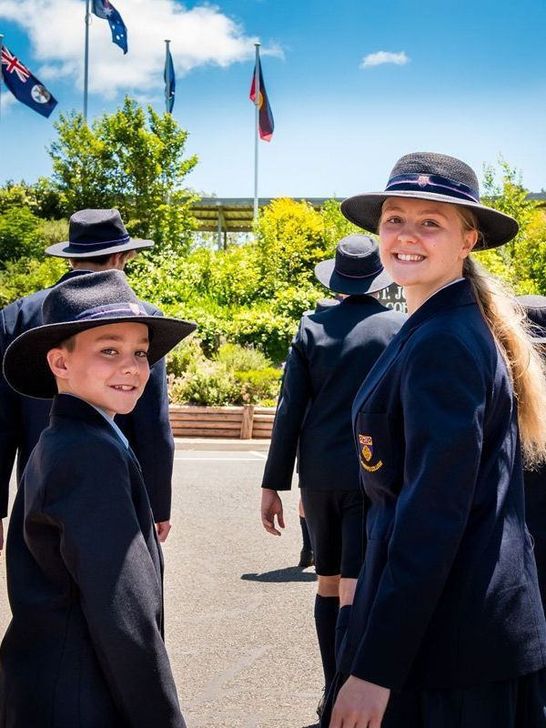 A group of people wearing hats are standing next to each other on a street.