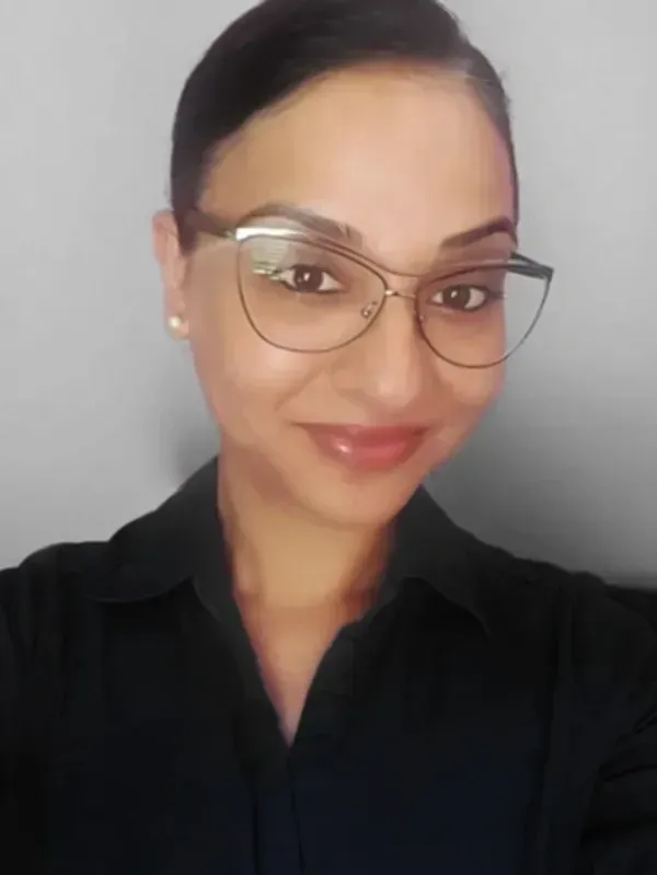 A woman wearing glasses and a black shirt is taking a selfie.