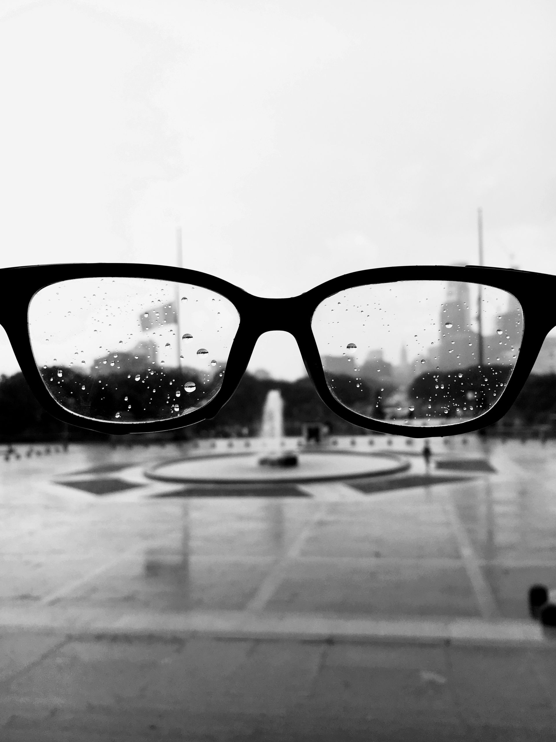 A pair of glasses with a fountain in the background