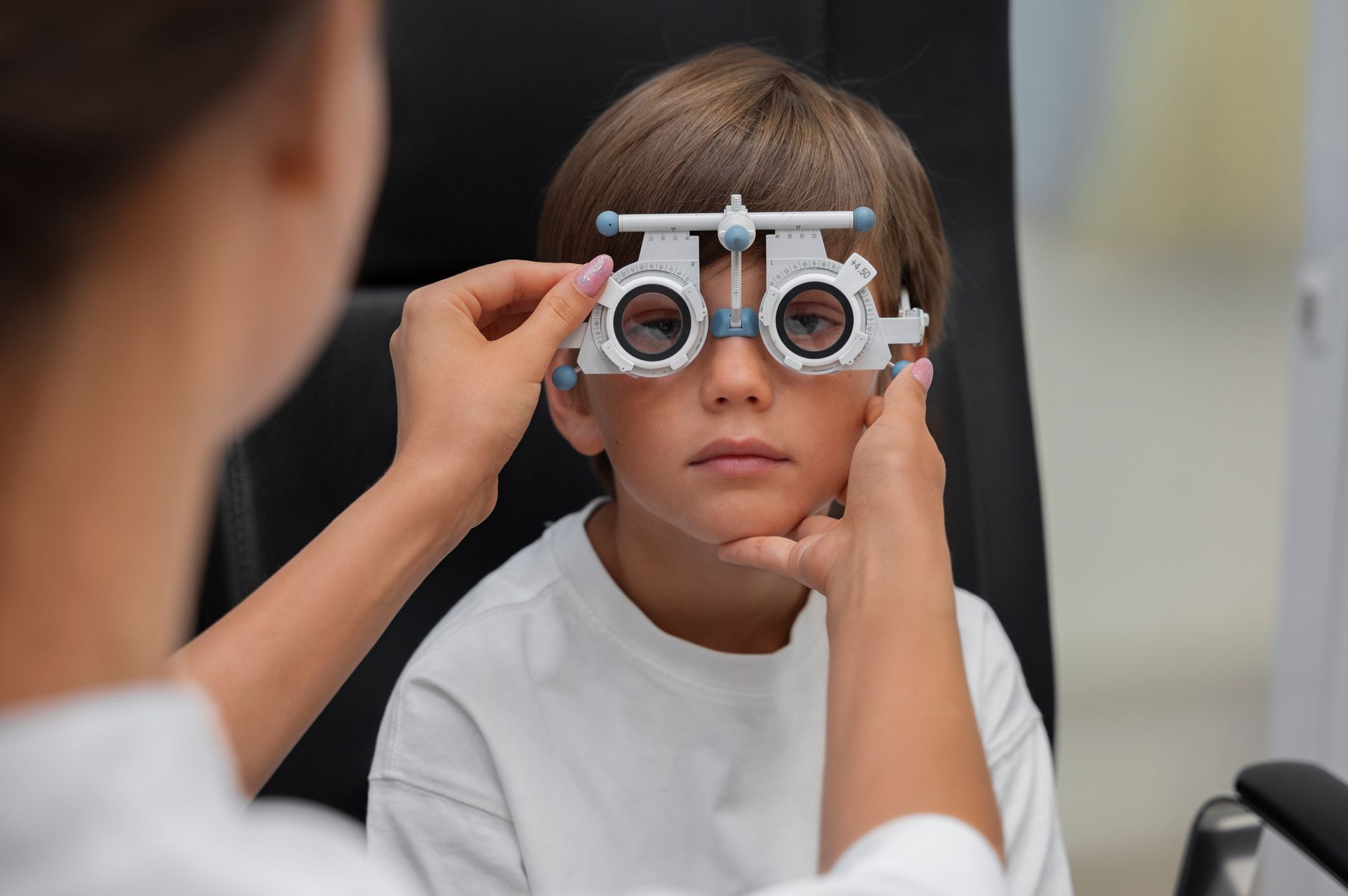 A young boy is getting his eyes checked by an ophthalmologist.