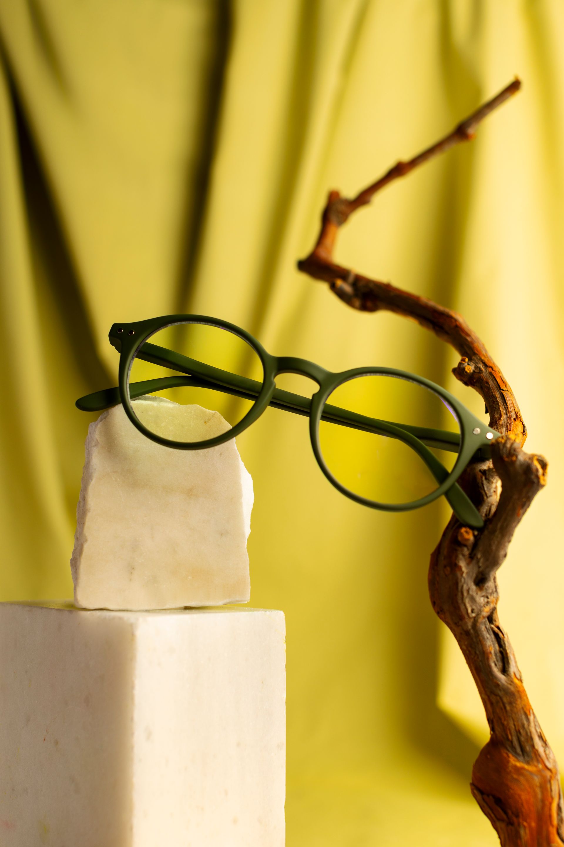 A pair of green glasses sitting on top of a marble block