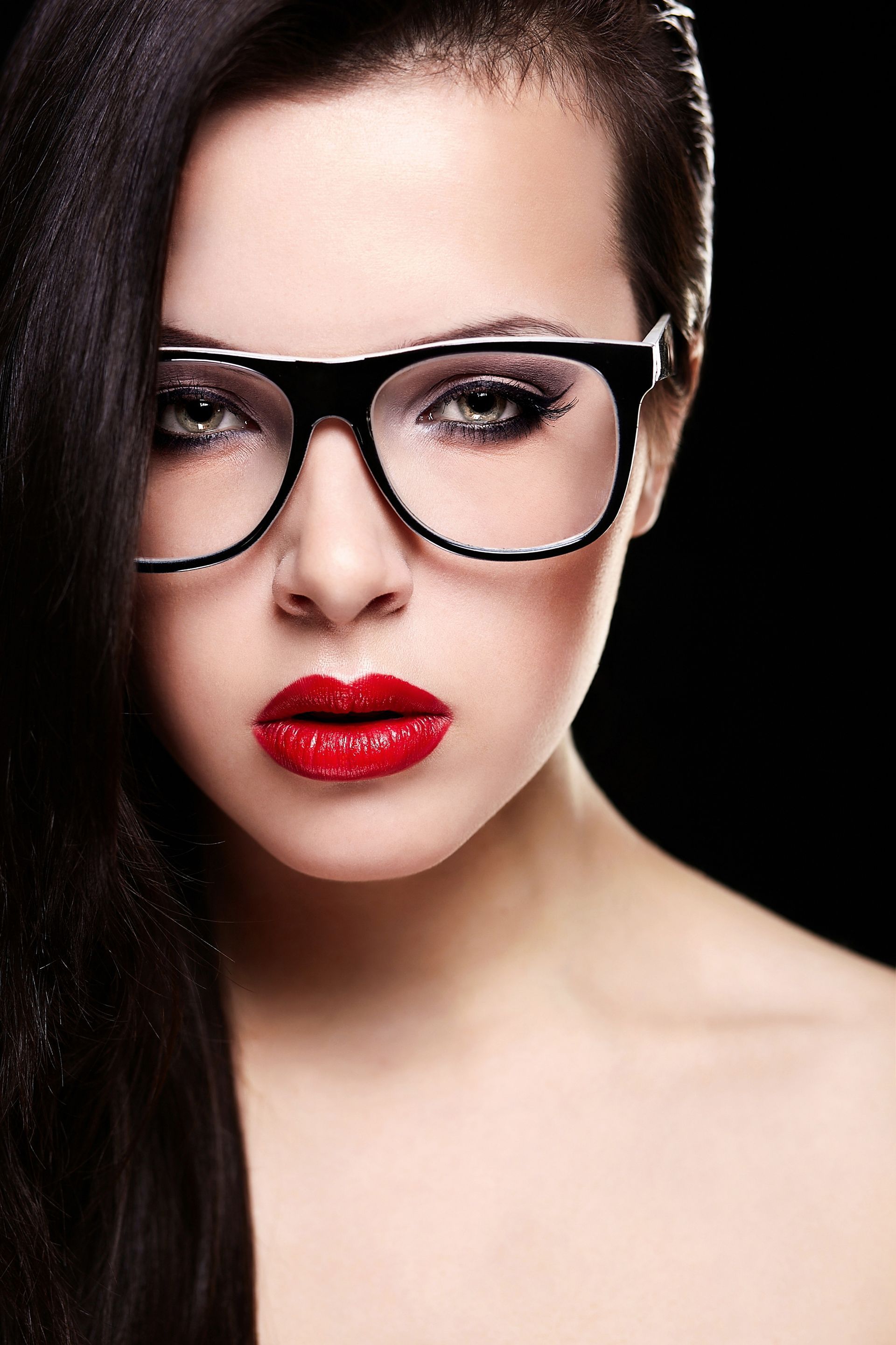 A close up of a woman wearing glasses and red lipstick