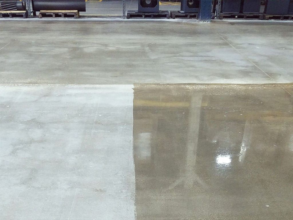 Wet concrete slab with a light gray section and a darker reflective section beside it.