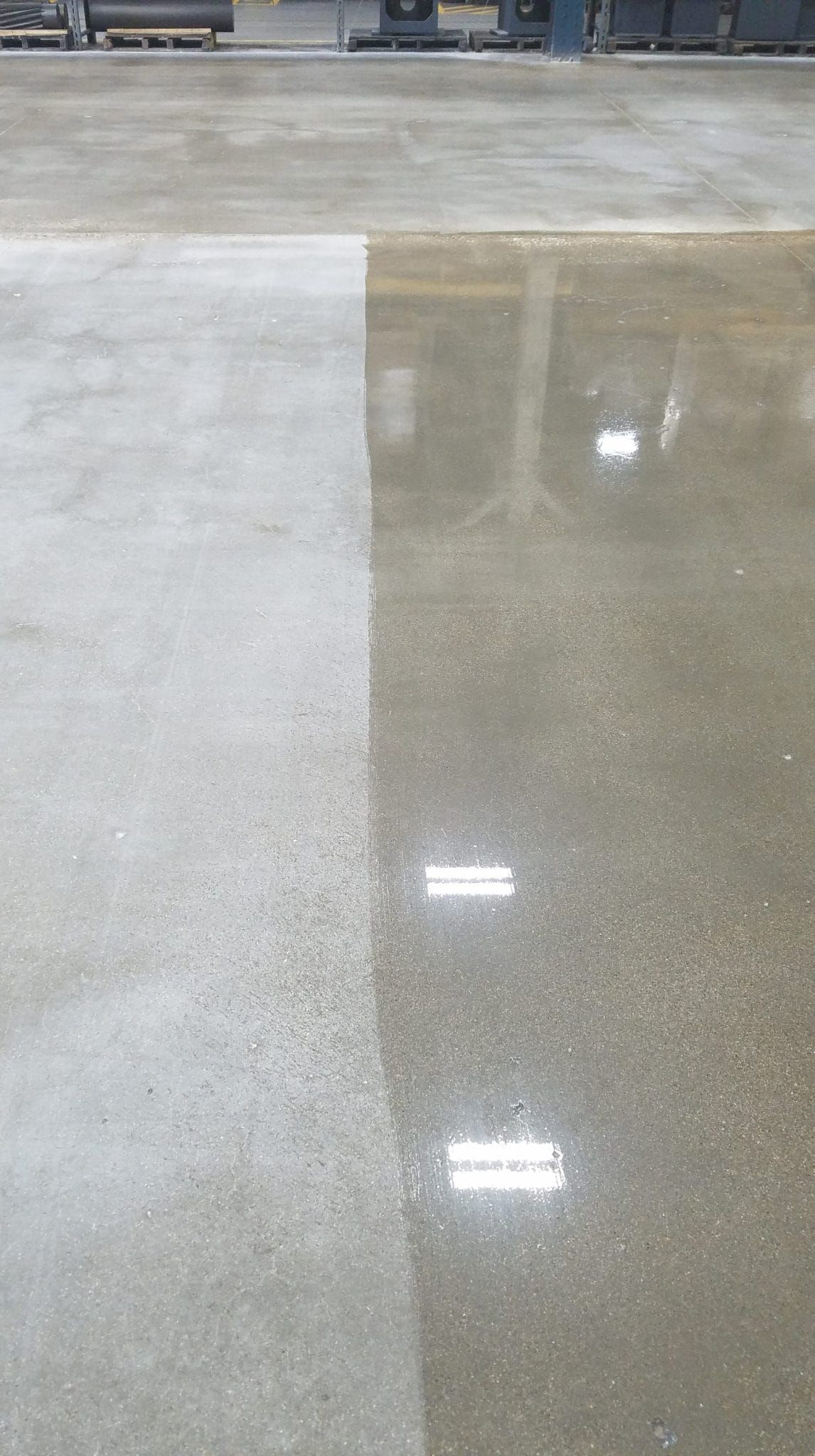 Dry and wet concrete floor with a visible boundary and light reflections from overhead lights.