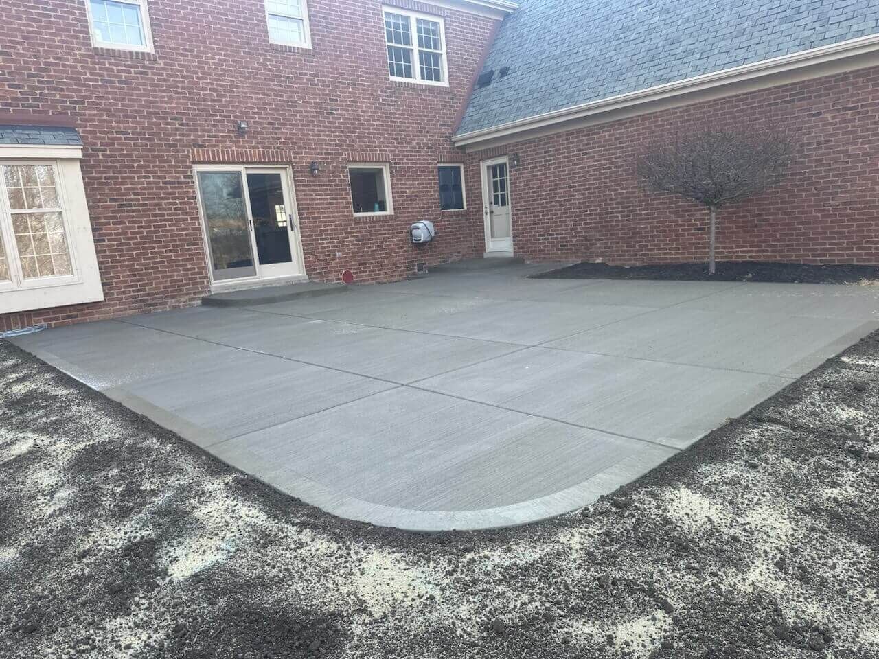 Brick building courtyard with a large concrete patio and a walkway along the wall