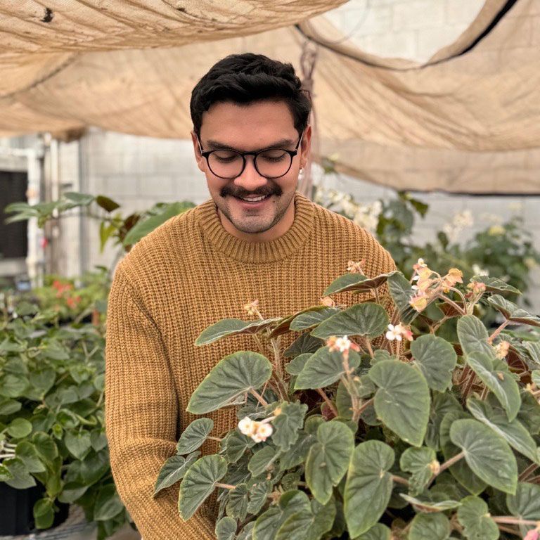 a woman is holding a potted plant in front of a sign that says `` take over '' .