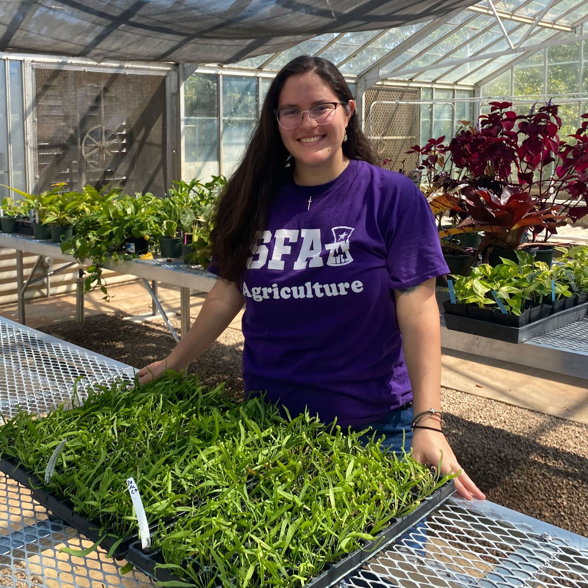 a woman is holding a potted plant in front of a sign that says `` take over '' .