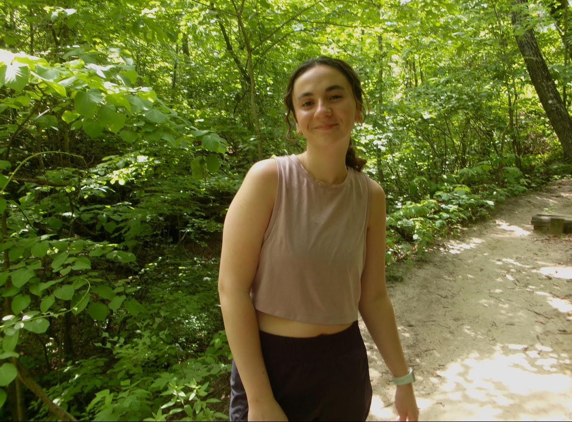 a woman is holding a potted plant in front of a sign that says `` take over '' .