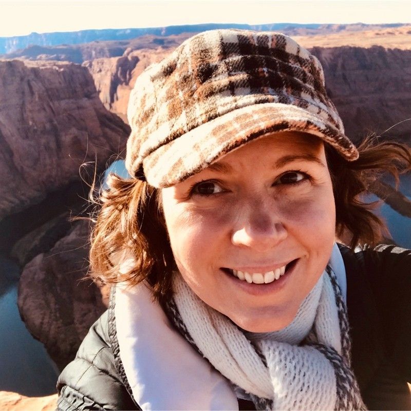 a woman is holding a potted plant in front of a sign that says `` take over '' .