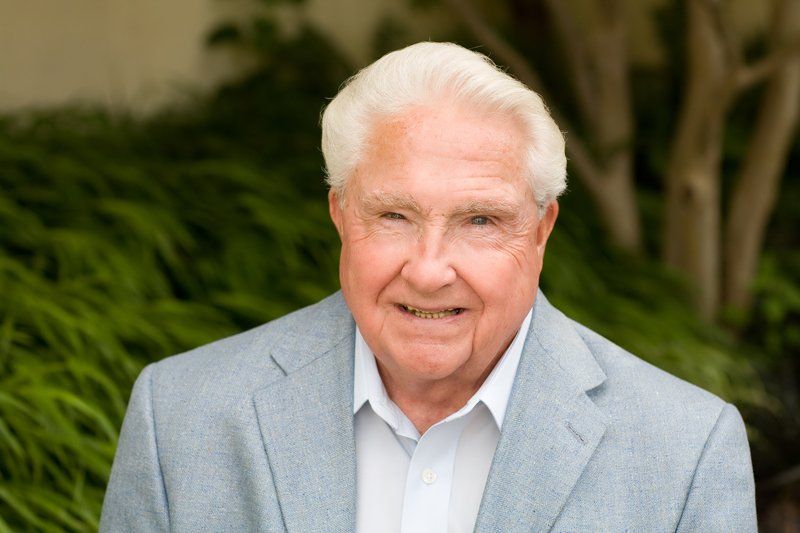 a man in a suit and white shirt is smiling for the camera .