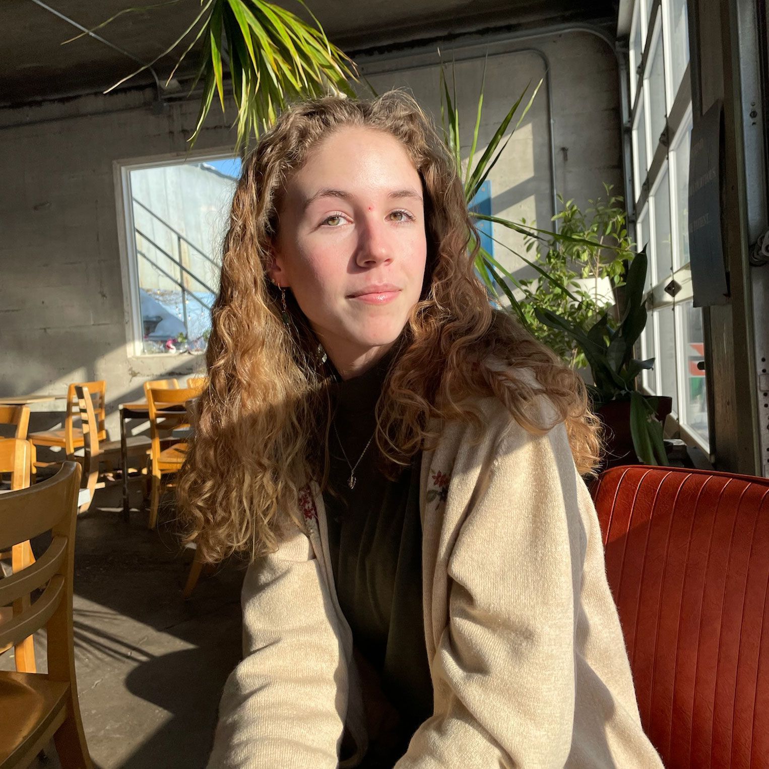 a woman is holding a potted plant in front of a sign that says `` take over '' .