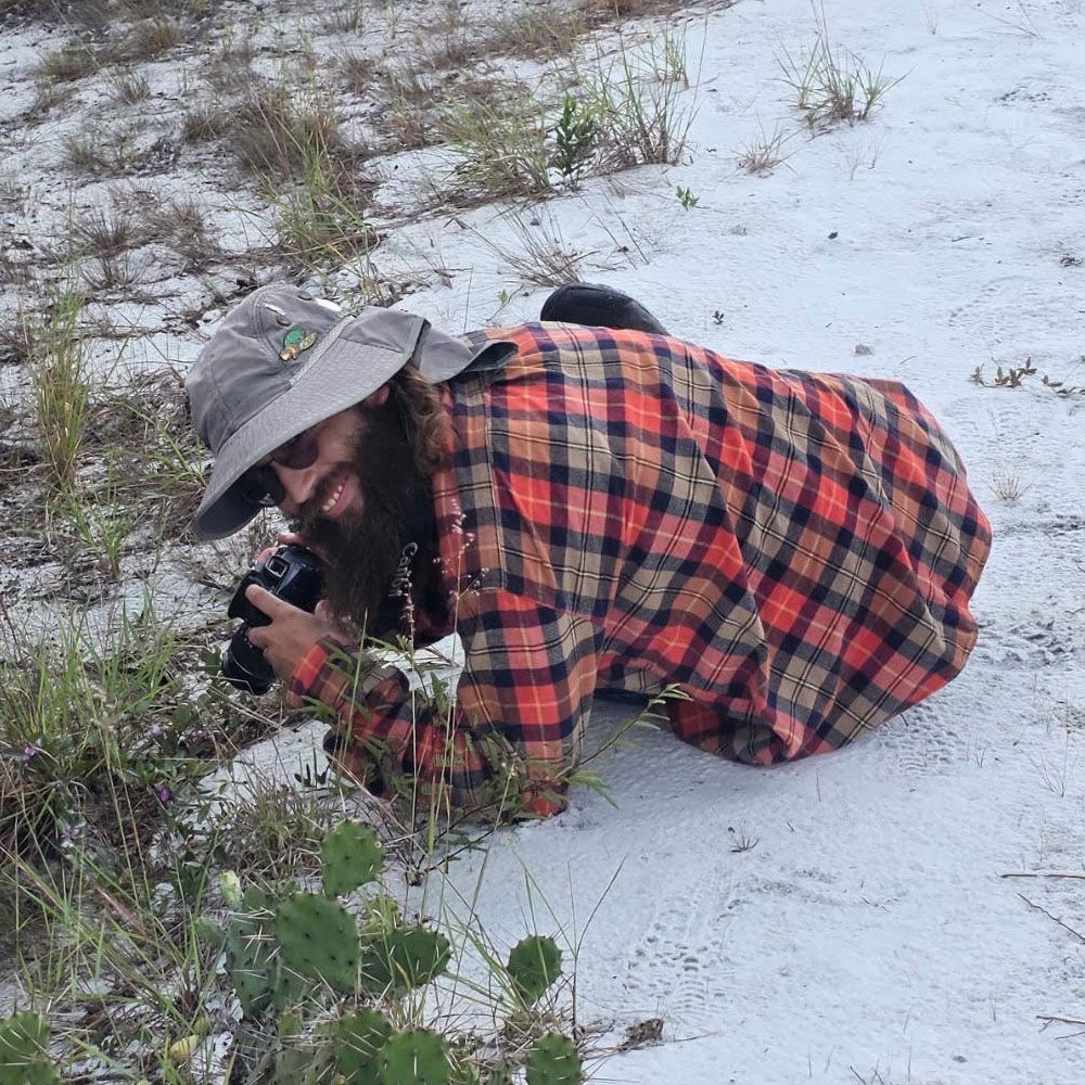 a woman is holding a potted plant in front of a sign that says `` take over '' .