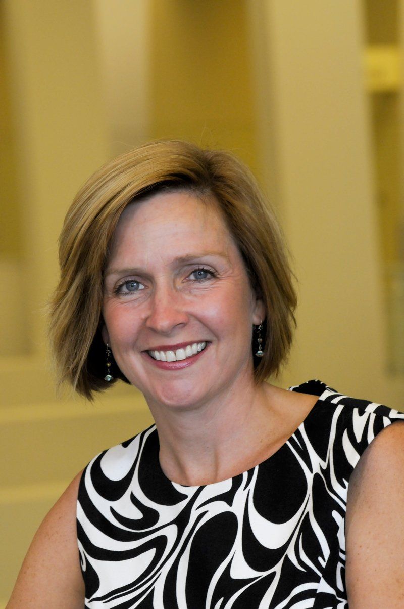 a woman in a black and white dress is smiling for the camera
