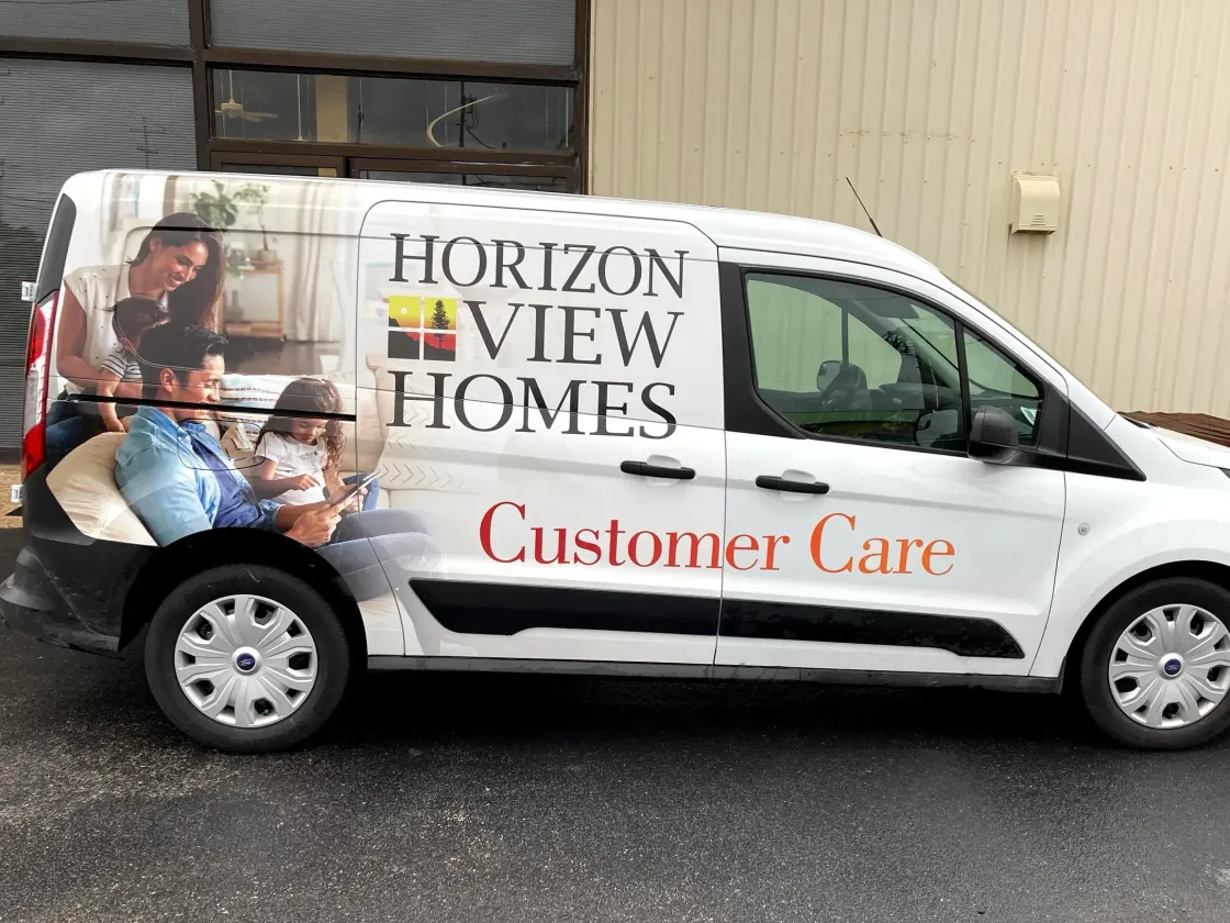 A horizon view homes van is parked in front of a building