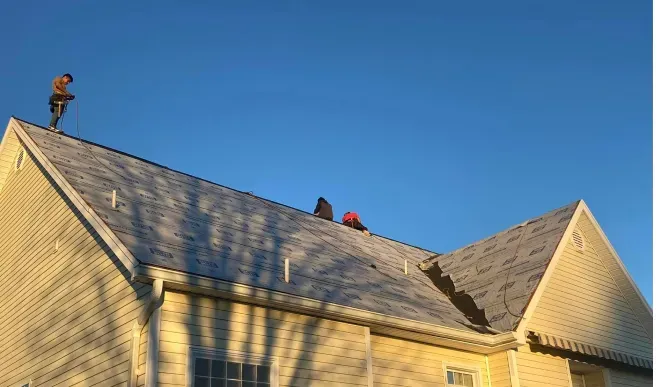 People on a rooftop working, clear blue sky.