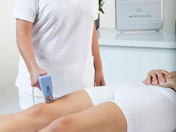 A woman is getting a laser treatment on her leg.