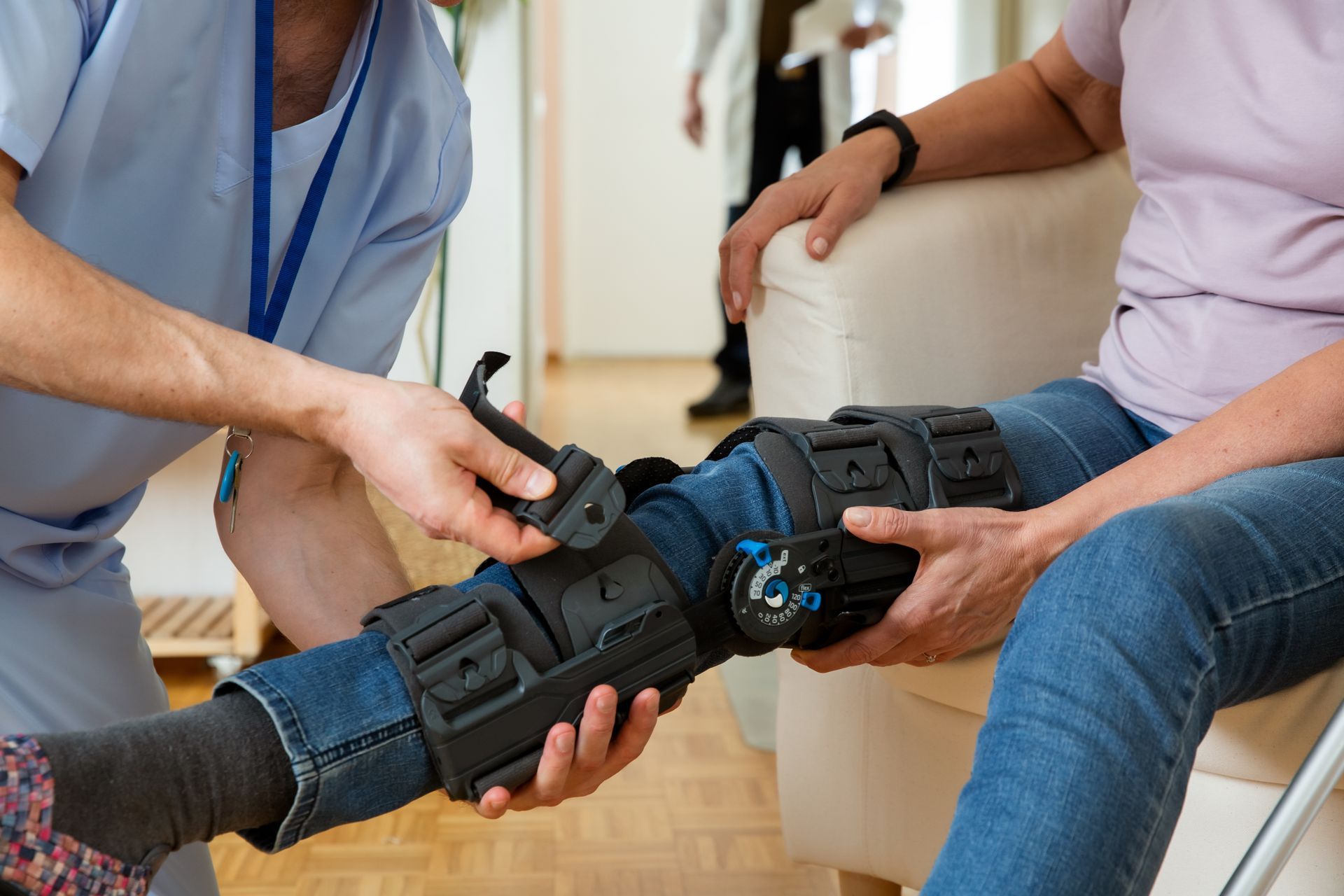 A man is putting a knee brace on a woman 's leg.