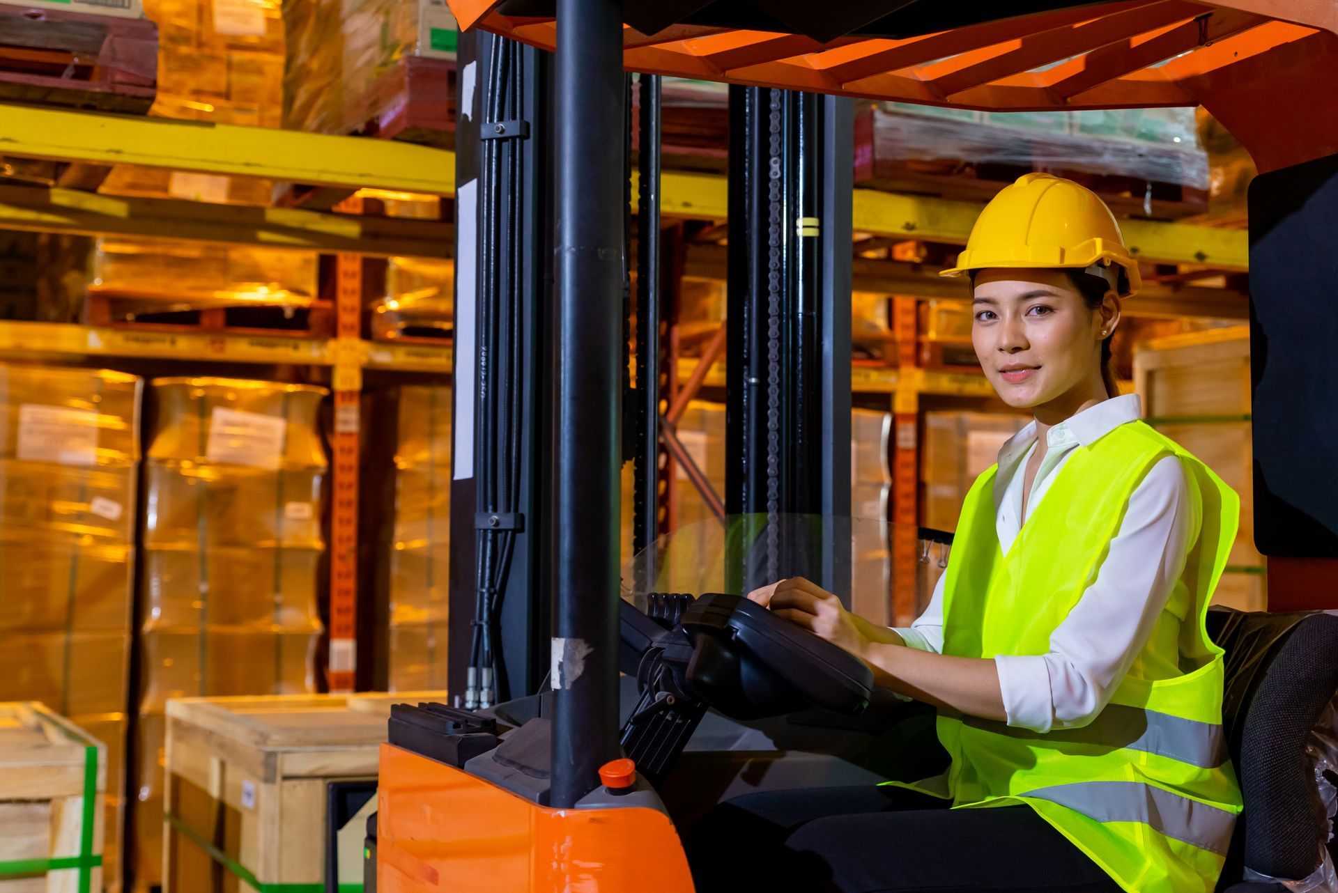 A woman is driving a forklift in a warehouse.