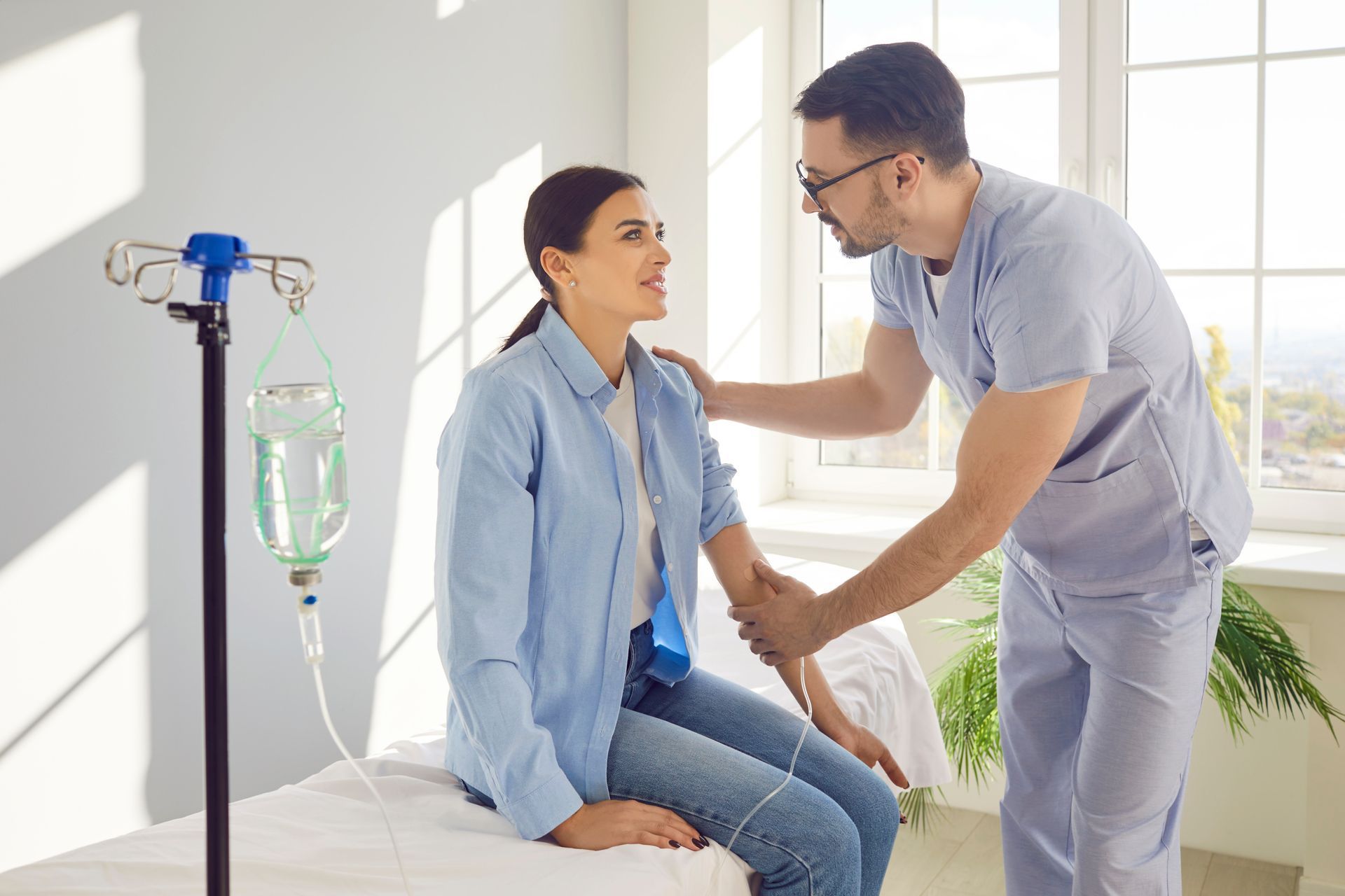 A nurse is putting an IV on a patient in a hospital bed.