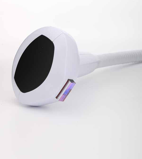 A close up of a hair removal device on a white surface.