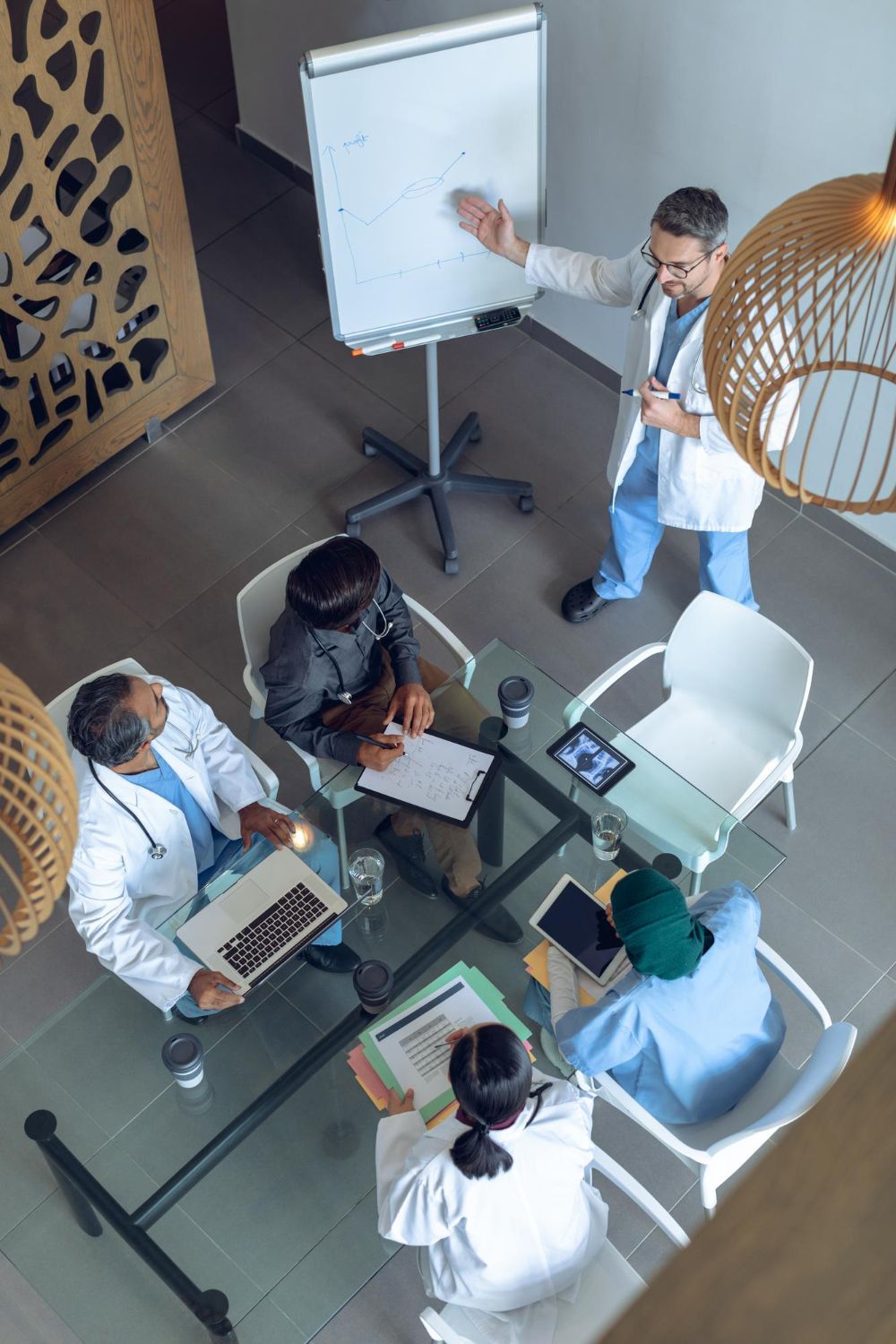 A man and a woman are sitting at a table looking at a laptop.