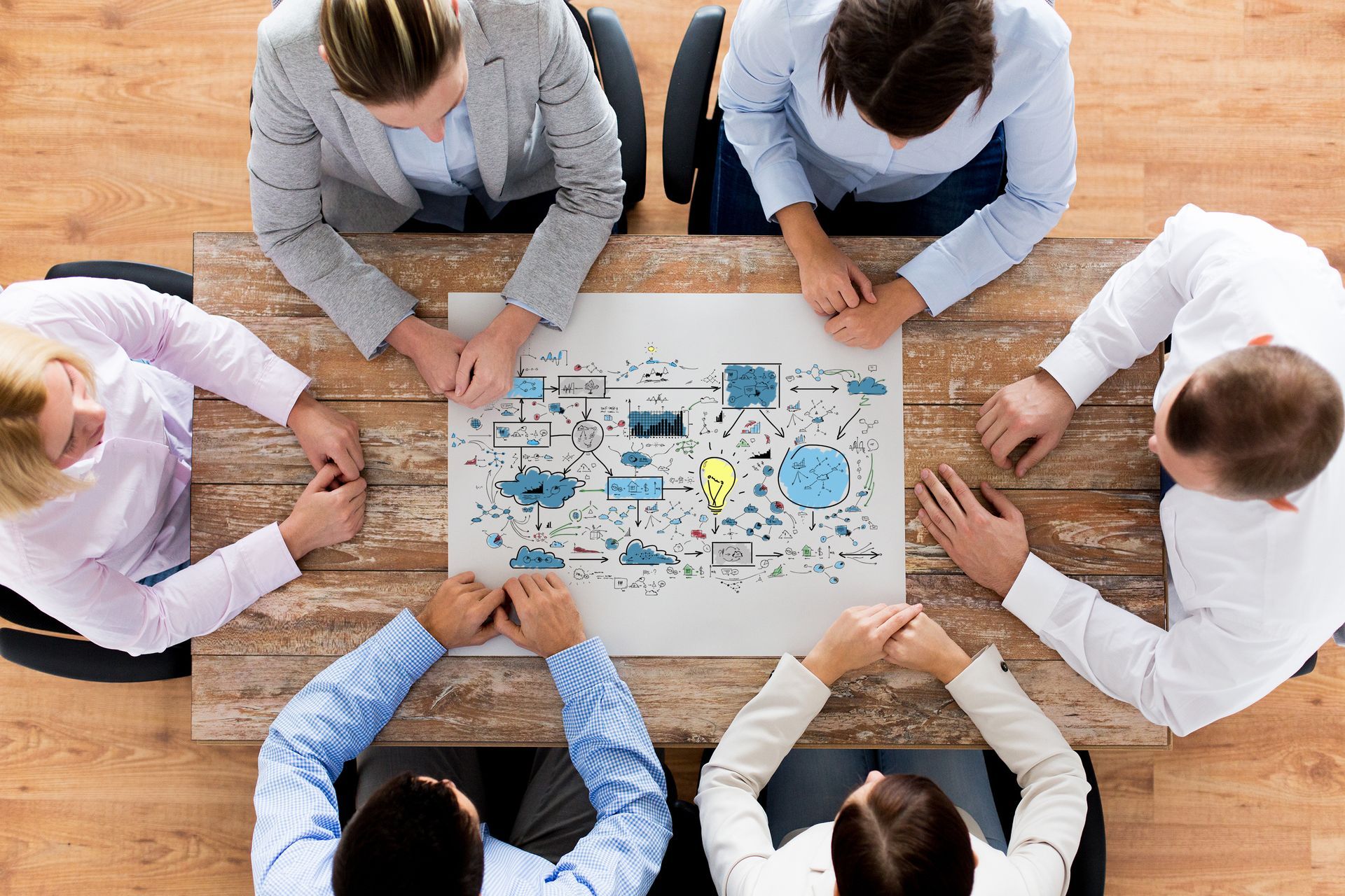 A group of people are sitting around a table having a meeting.