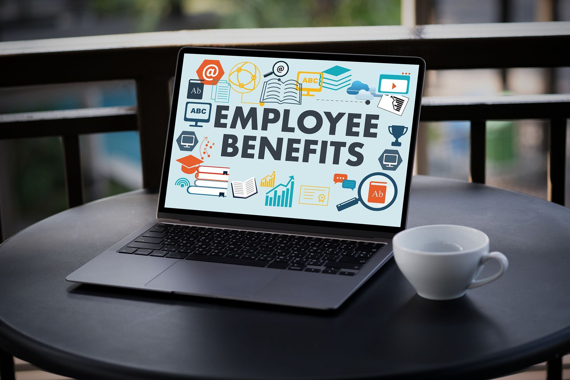 A laptop computer is sitting on a table next to a cup of coffee.