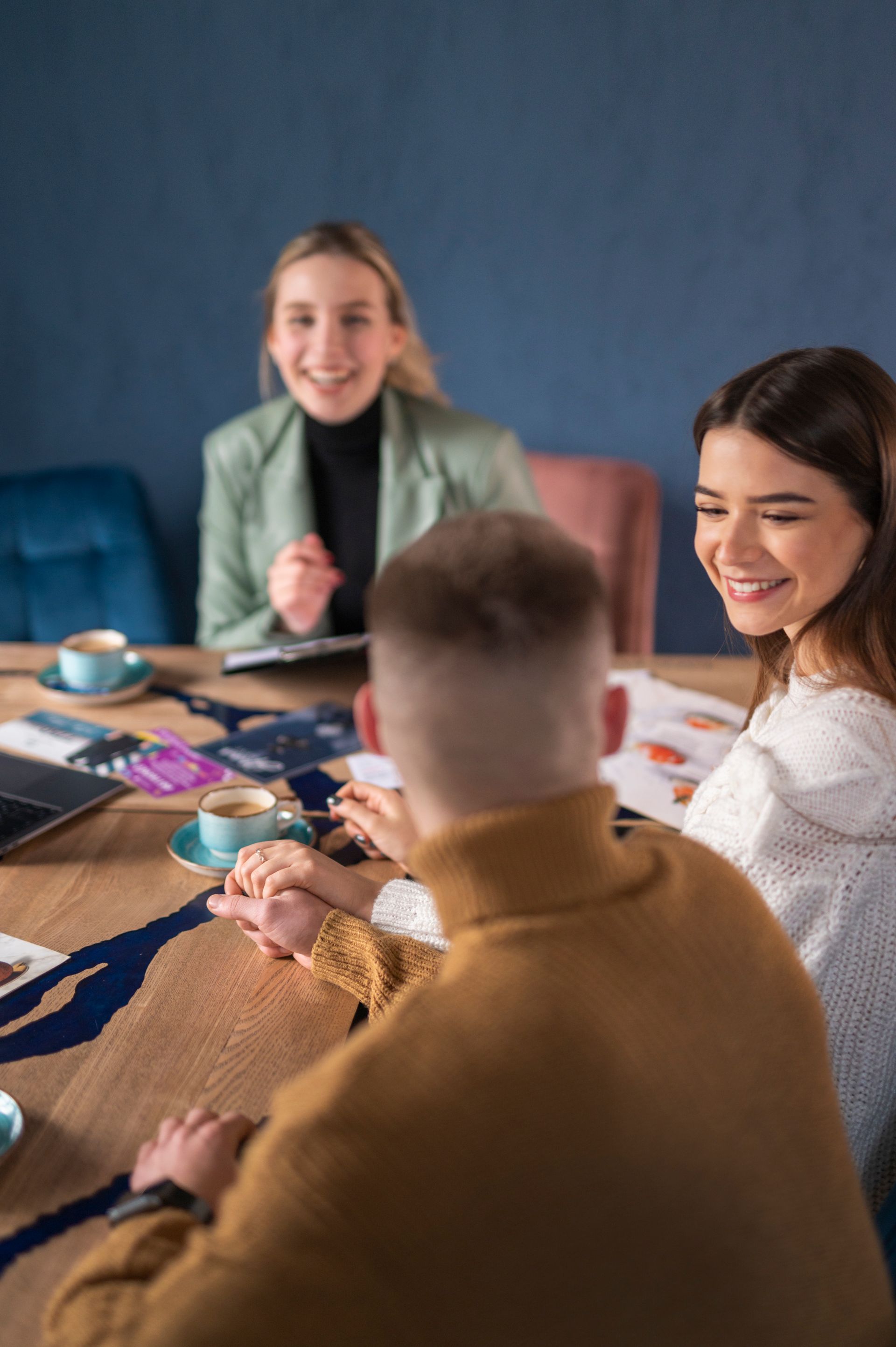 A group of people are sitting around a table having a meeting.