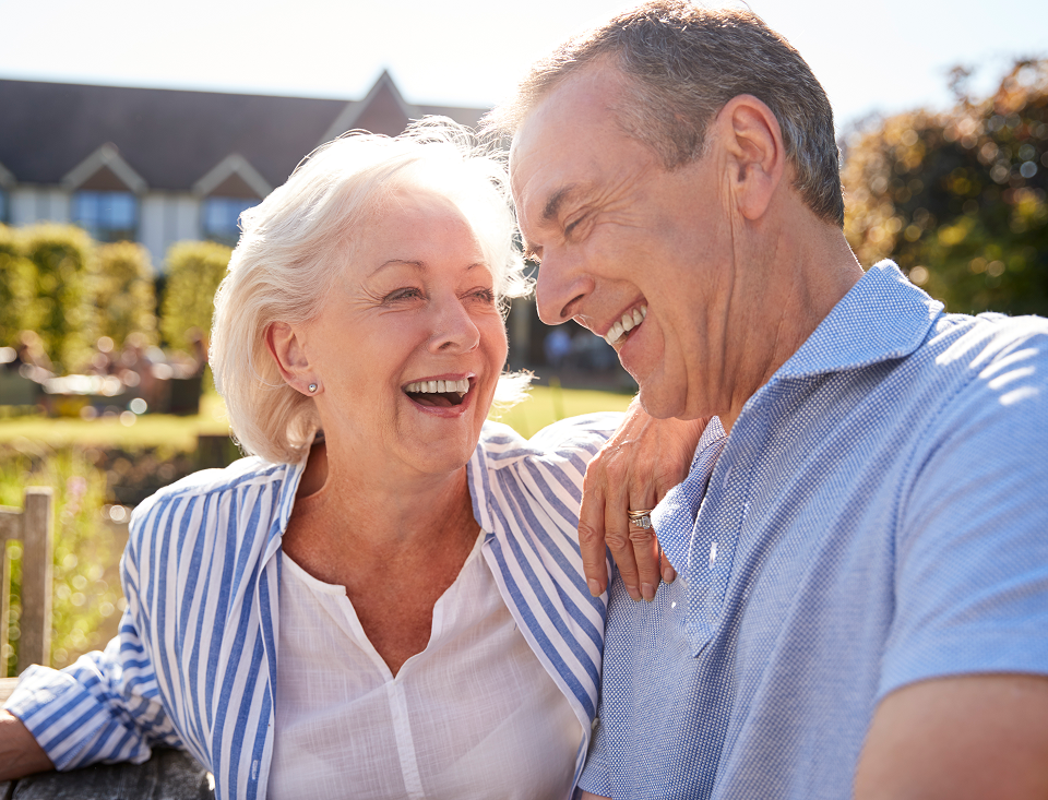 A man and a woman are sitting next to each other and smiling.