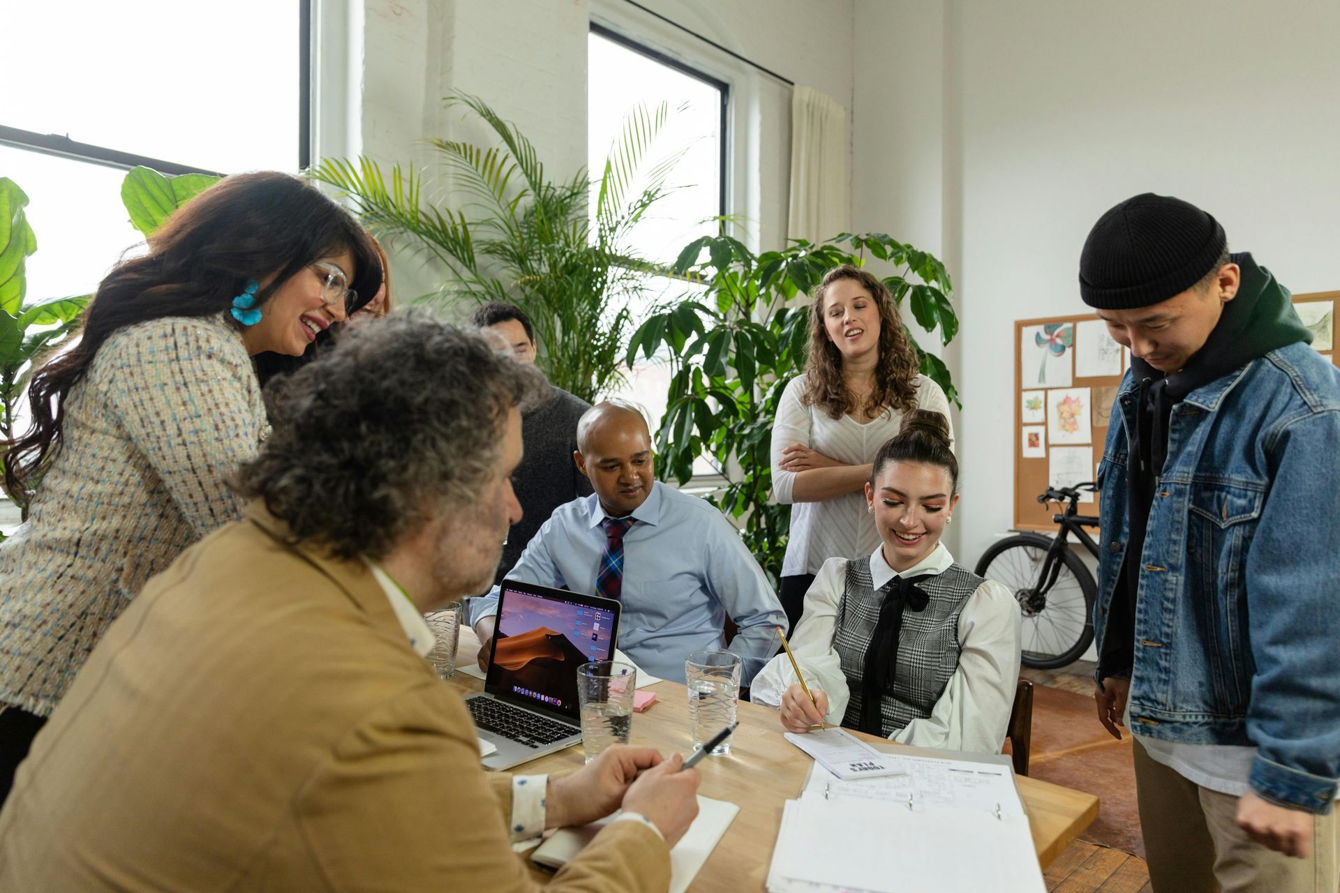 A group of people are sitting around a table having a meeting.