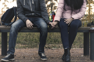 Young Couple Holding Hands on Bench