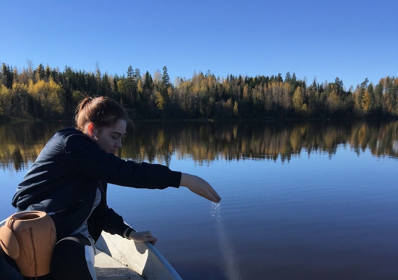 Young Lady Scattering Ashes Into Lake