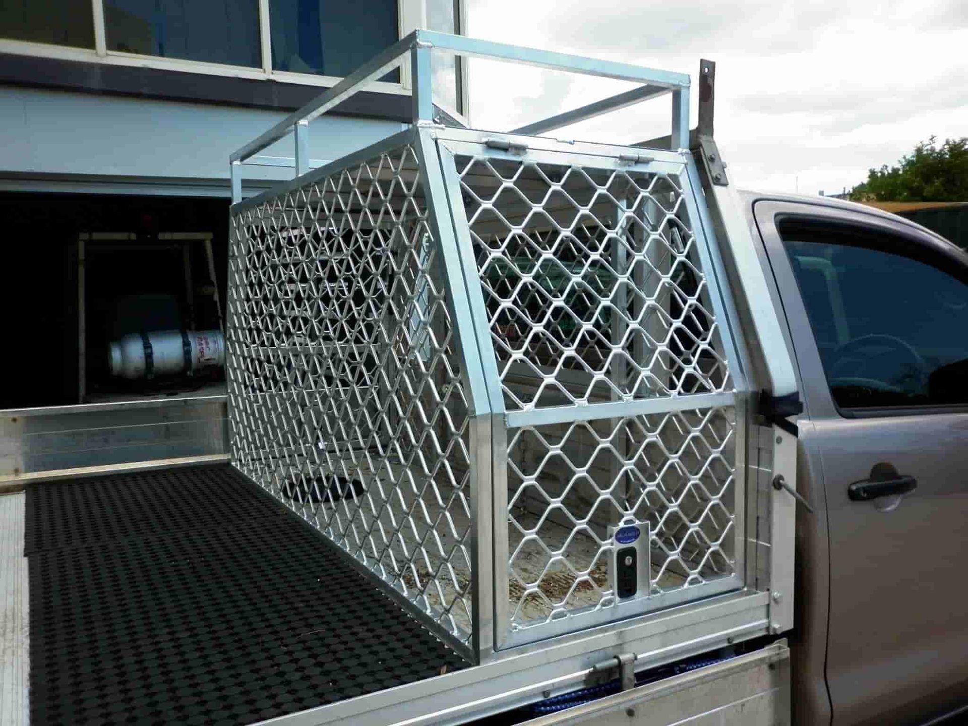 A Truck With a Cage in the Back is Parked in Front of a Building — Aliweld Fabrications In Caloundra West, QLD