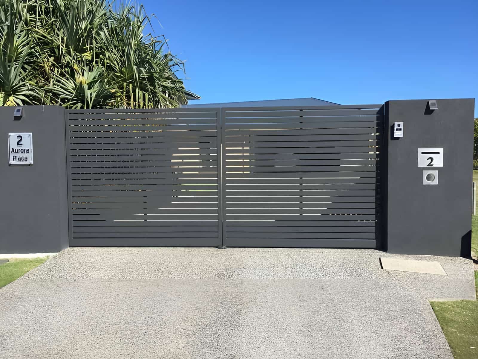 A Black Sliding Gate Is Open To A Driveway In Front Of A House — Aliweld Fabrications In Sunshine Coast, QLD