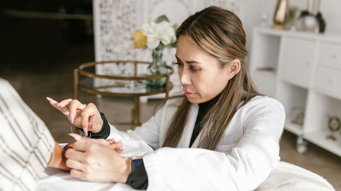 Acupuncturist performs acupuncture on a patient