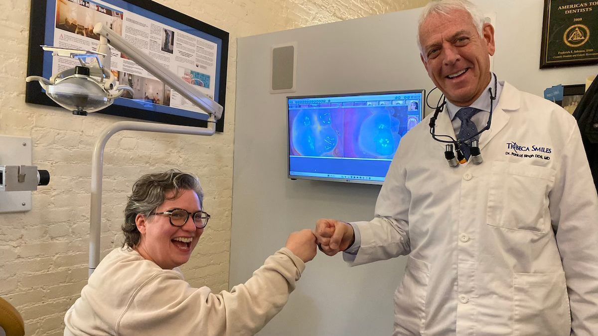 Dr. Solomon and a dental patients exchange fist bumps after tooth extracion