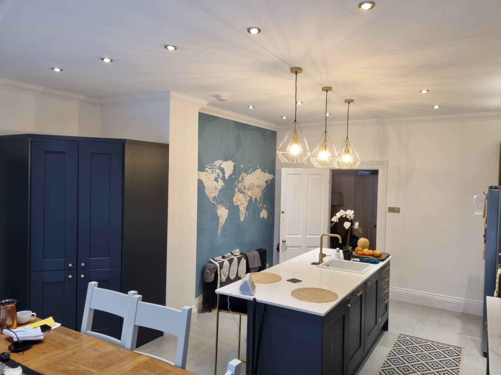 A kitchen with a large island and a map of the world on the wall.