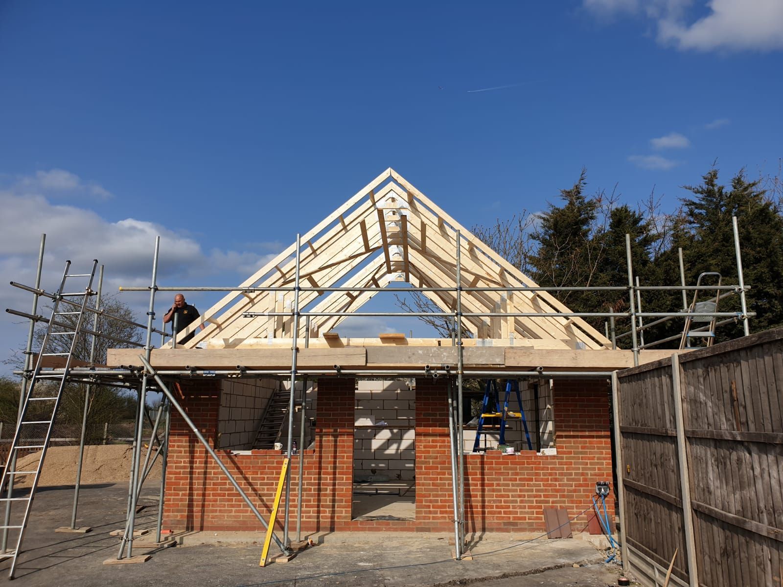 A man is working on the roof of a building under construction.