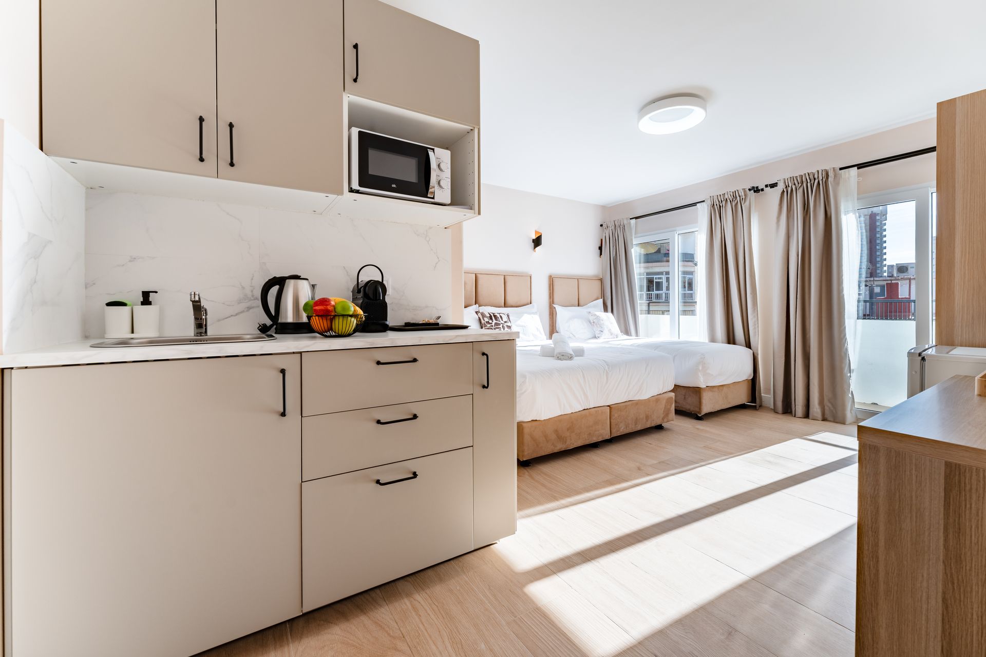 Apartamento tipo estudio con cocina americana, cama y luz natural gracias a una ventana. 