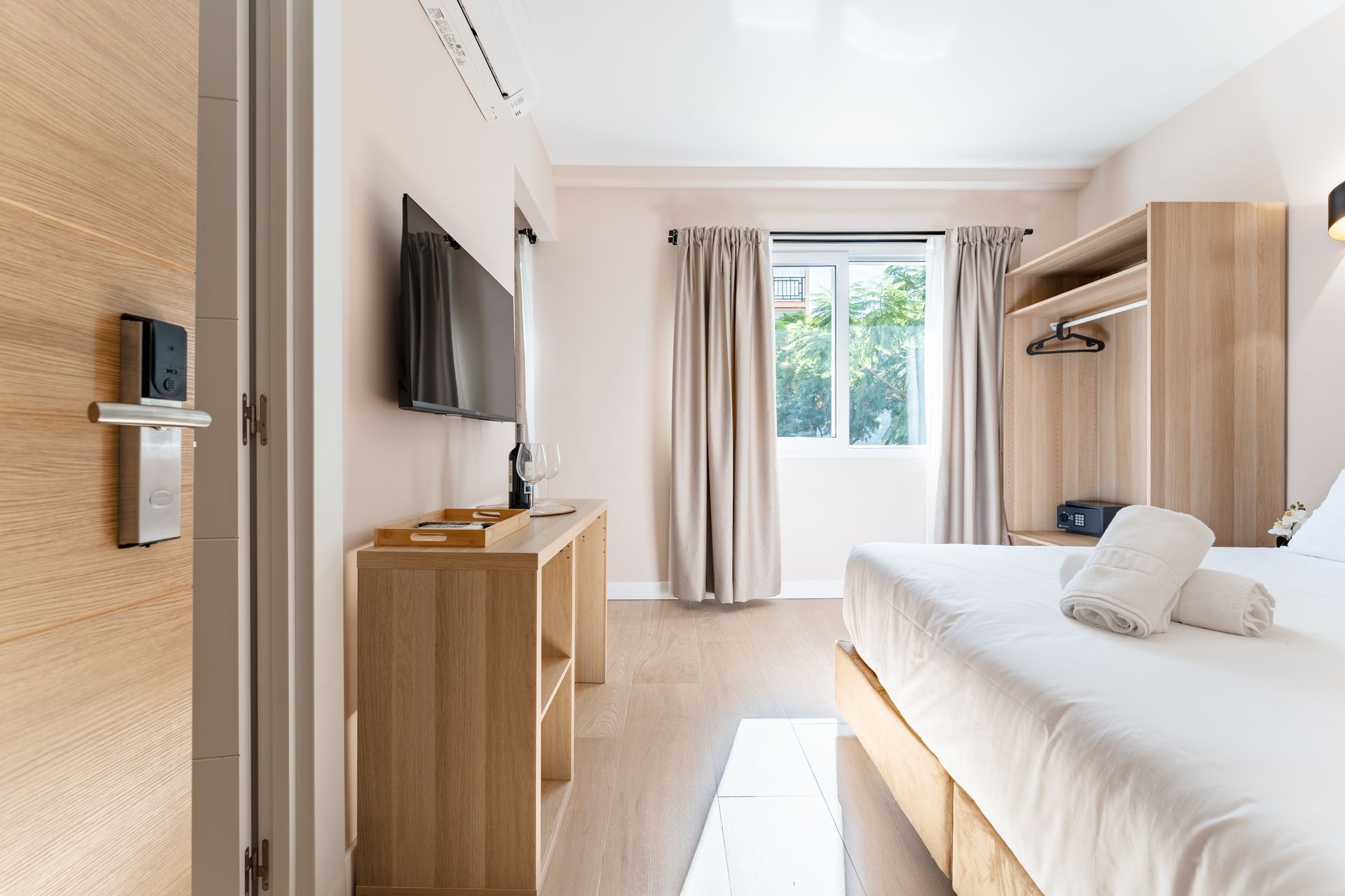 Habitación de hotel con cama, televisión, armario y muebles de madera.