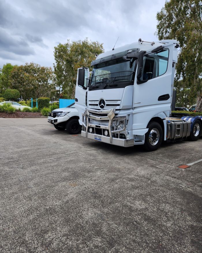 A White Semi Truck is Parked Next to  a Parking Lot — Smart Automotive Technologies in Noosaville, QLD