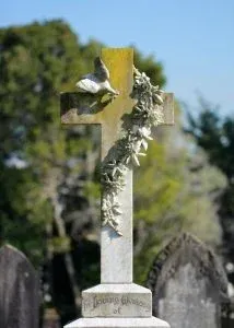 a cross in a cemetery with some flowers