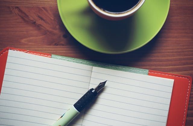 Notebook and cup of coffee on a wooden table create a quiet scene for funeral homes New Orleans, LA