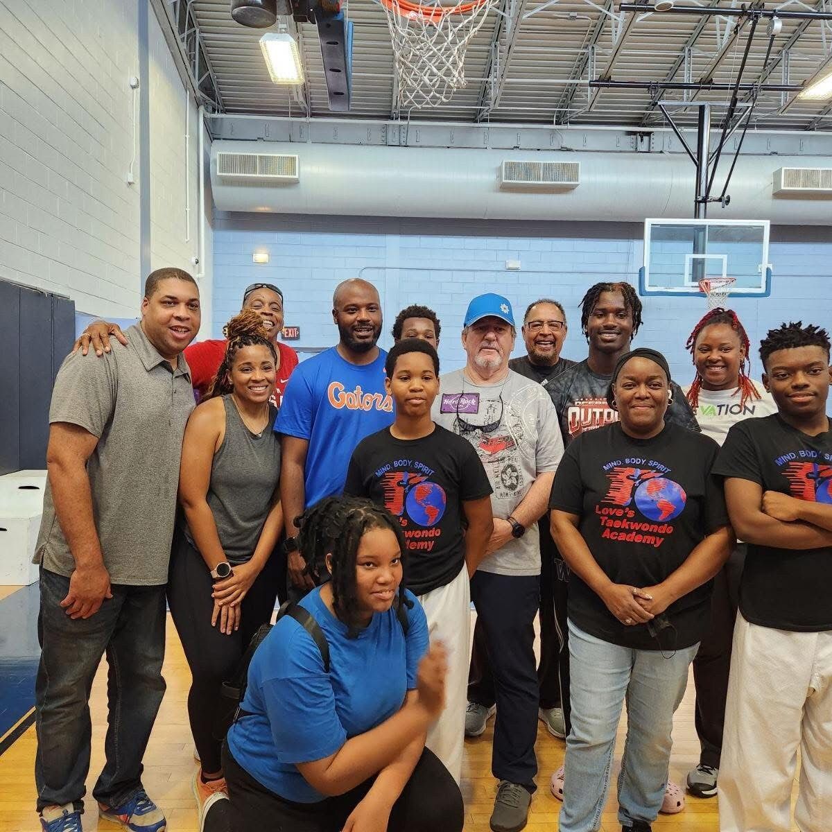 A group of people posing for a picture with one man wearing an oxford shirt